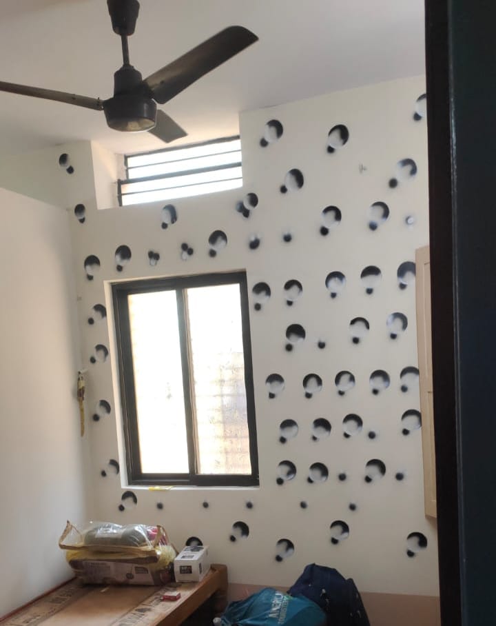 Modern wall design inside a Boys PG room in Hubli showing a large window for natural light and a ceiling fan for ventilation.